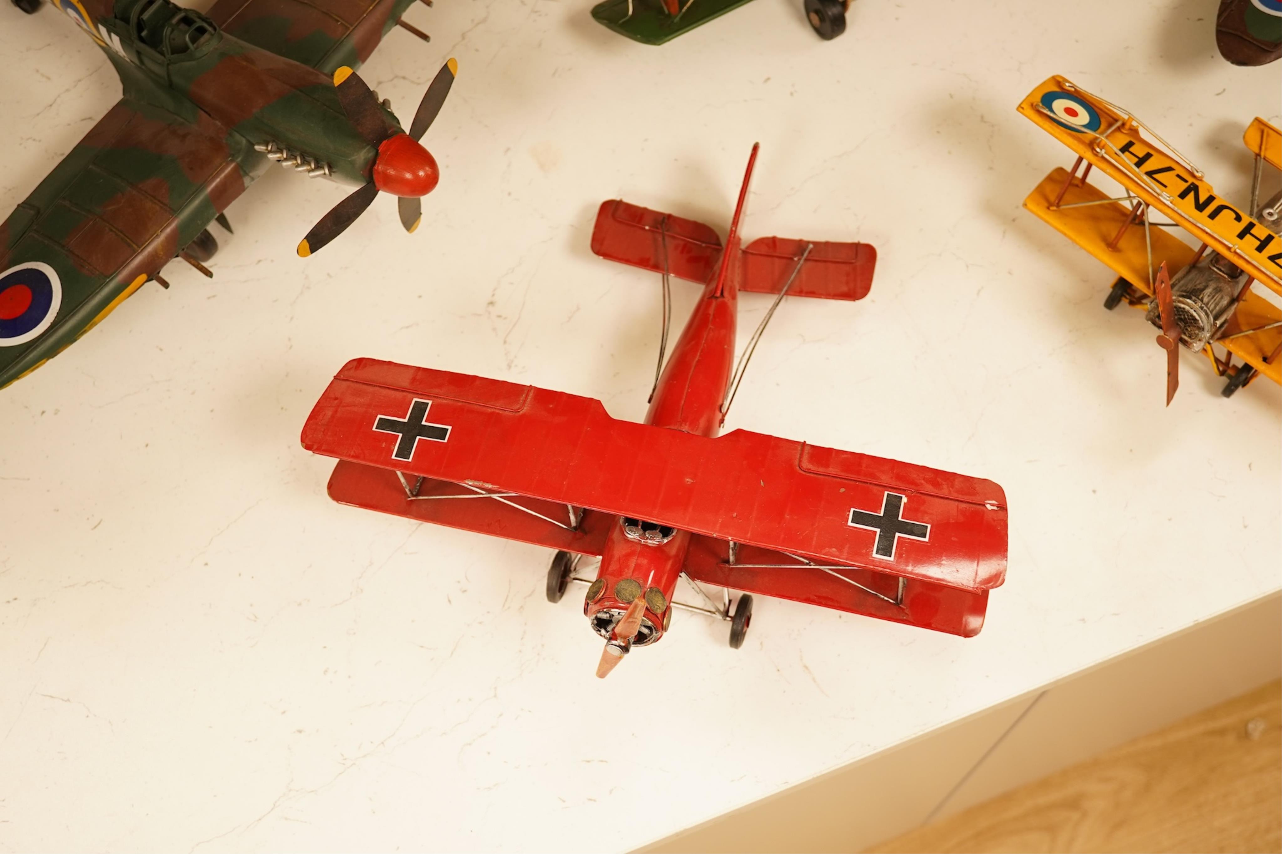 Five decorative metal models of military aircraft, including two Supermarine Spitfires, two First World War, British bi-planes, a German Albatros D.III bi-plane, and a wooden model of RMS Queen Mary, hull 77cm long
